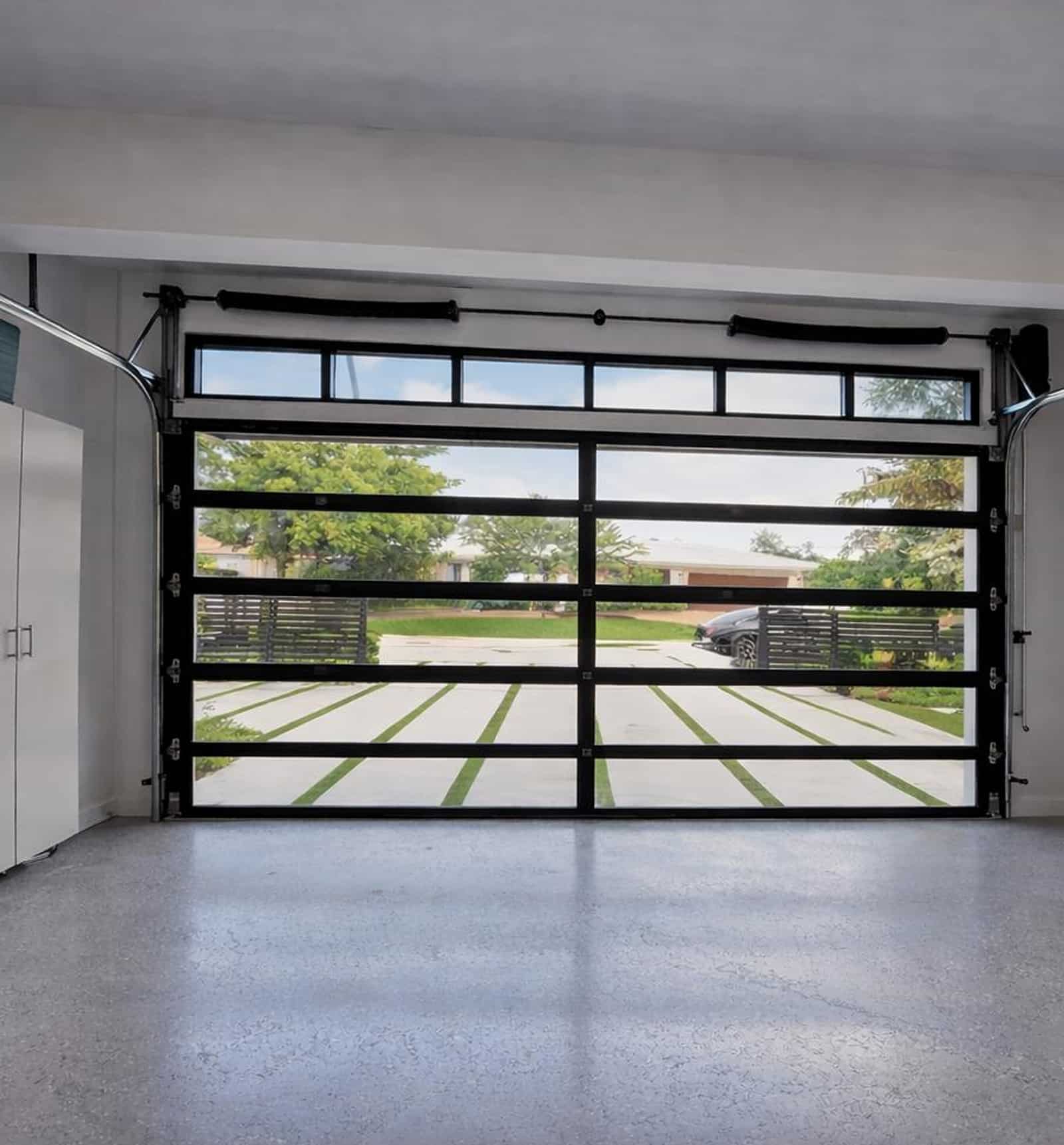 Frameless glass garage doors on a modern residential home